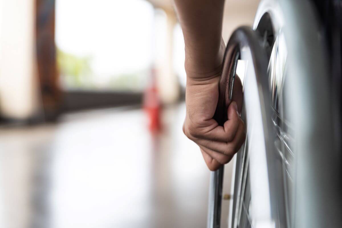 Image of hand on a wheelchair wheel